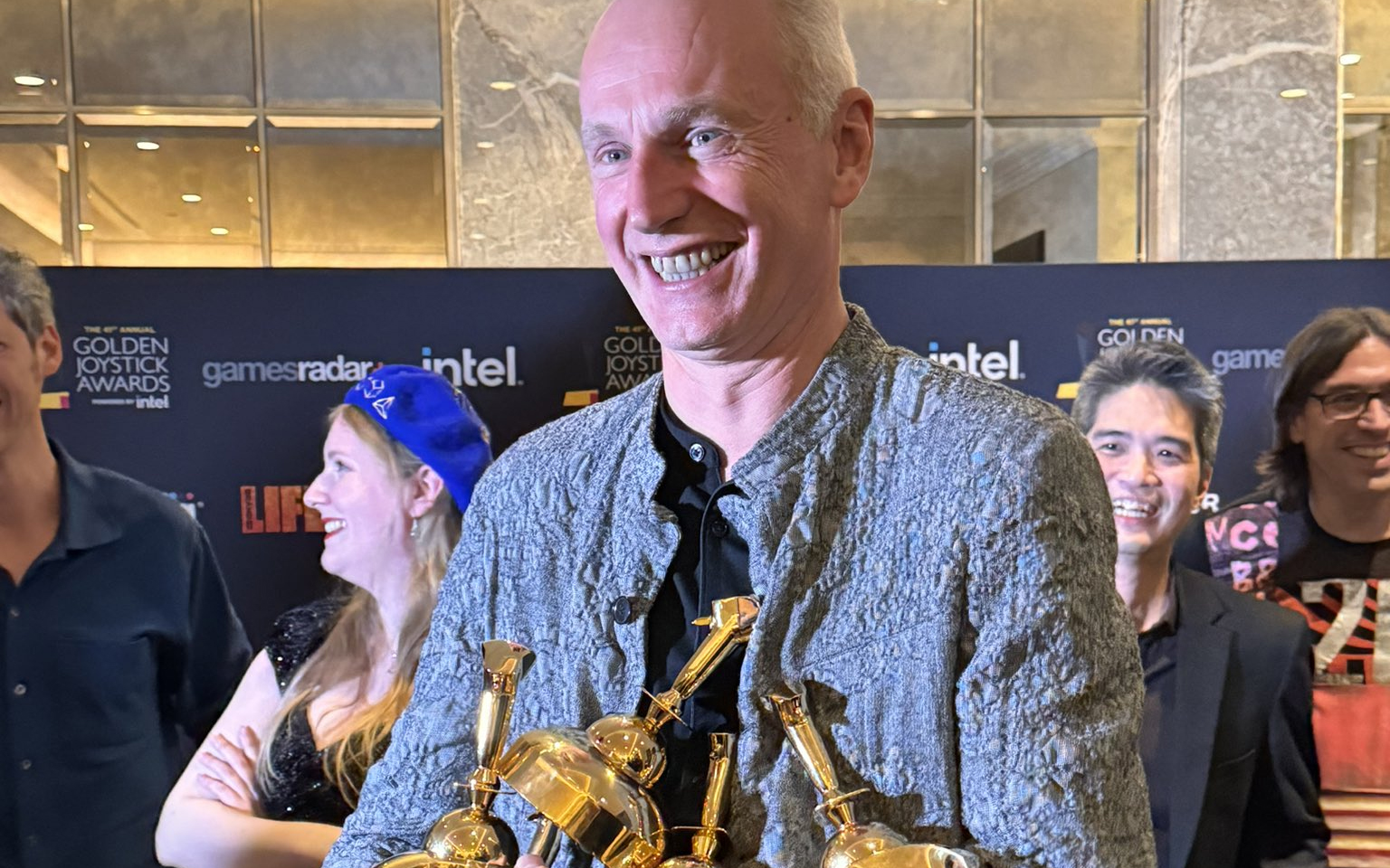 Swen Vincke holding multiple Golden Joystick Awards, symbolizing the success of Baldur's Gate 3